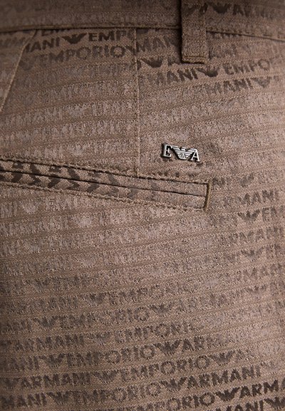 Rudas medžiaga su tekstūruota raštu, kuriame kartojasi prekės ženklas "Emporio Armani". Pridedama mažytė sidabrinė logotipo detalė.