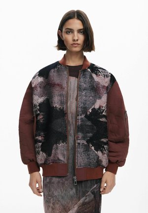 Quilted Bomberjacke aus dunkellila und abstrakt gemustertem Stoff, mit strukturierten Ärmeln, gerippten Bündchen und einem Frontreißverschluss.