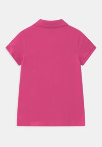 Růžové polo triko zezadu, s klasickým límečkem, krátkými rukávy a hladkou texturou látky, s přímým spodním lemem.