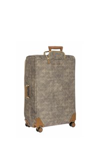 Valise en tissu tissé beige et marron avec des accents beige clair, deux poignées latérales et des roulettes pour la mobilité. Forme carrée et fermeture à zip.
