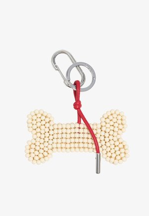 Knochenförmiger Schlüsselanhänger aus cremefarbenen Perlen, mit einem roten Lederband und einem silbernen Metallclip zur Befestigung.