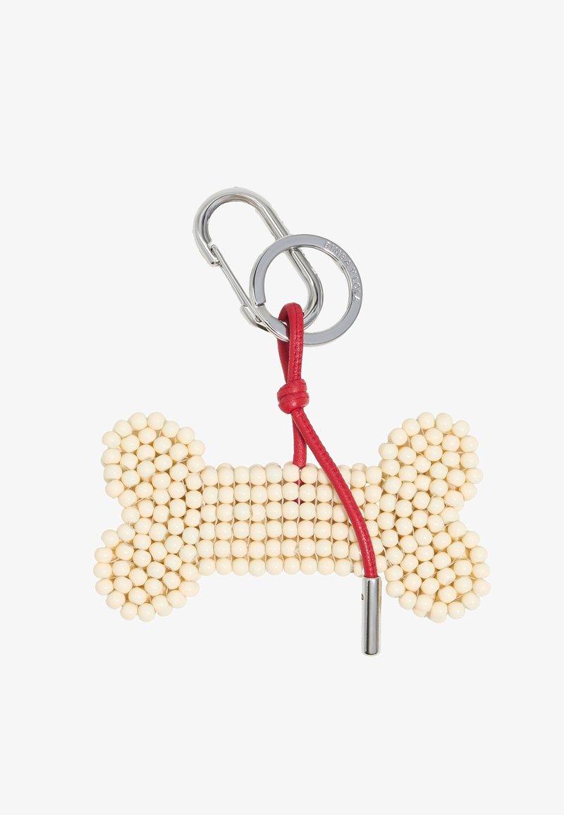 Ključna veriga v obliki kosti, izdelana iz kremastih kroglic, z rdečim usnjenim trakom in s srebrnim kovinskim sponko za pritrditev.
