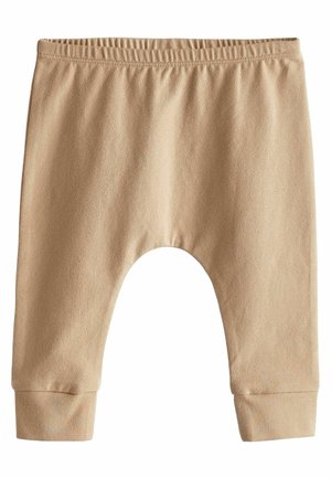 Beige kinderpantalon met een elastische tailleband, taps toelopende boorden en een zachte, gladde textuur. Heeft een oversized, afgeronde vorm voor extra comfort.