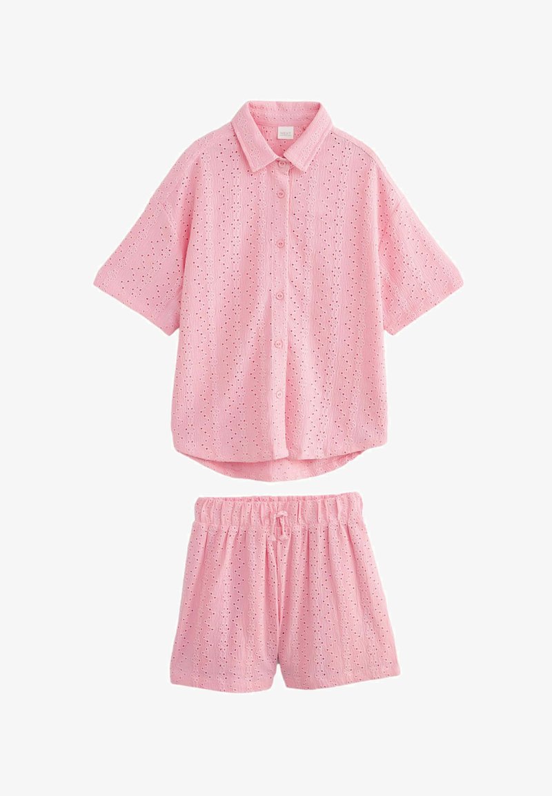 Heled roosa, lühikeste varrukatega nööpidega särk, millel on silmkoeliste mustritega detailsus, koos sobivate lühikesed pükstega, millel on elastne vöökoht.