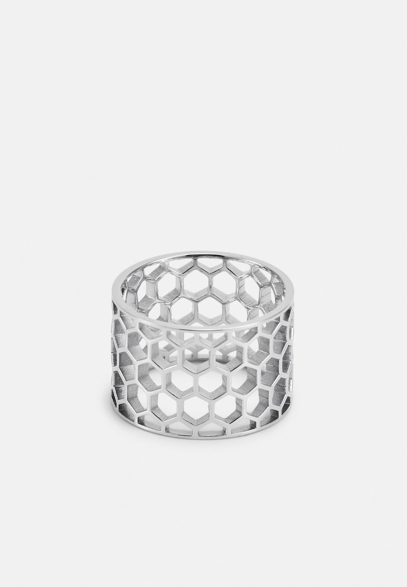 Bague en argent avec un motif en nid d'abeille composé de découpes hexagonales, présentée sur un fond clair uni.