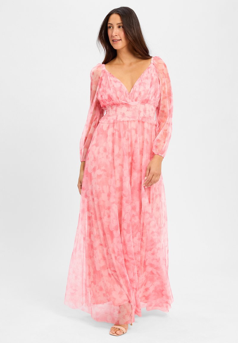 Maxi dress in sheer, pink fabric with floral pattern. Features long, puffed sleeves, deep V-neck, and a smocked waistband.