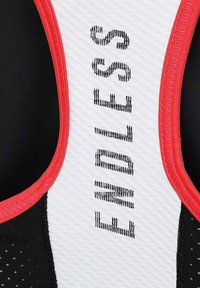 Canottiera atletica in bianco e nero con un motivo a rete traspirante, dettagli rossi e la parola "ENDLESS" stampata verticalmente sul lato.
