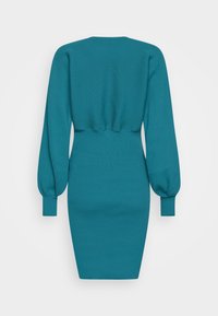 Robe côtelée bleu sarcelle avec manches ballon longues et silhouette ajustée. Elle présente un col rond et un ourlet effilé. Tissu tricoté texturé.