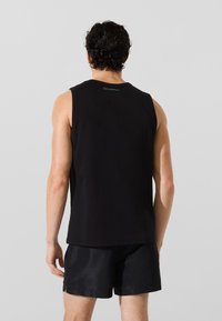 Juodas beRankovių marškinėlis, pagamintas iš minkštos medžiagos, su tiesiu apdaila ir minimalistiniu dizainu, ant nugaros esantis mažas mėlynas logotipas.