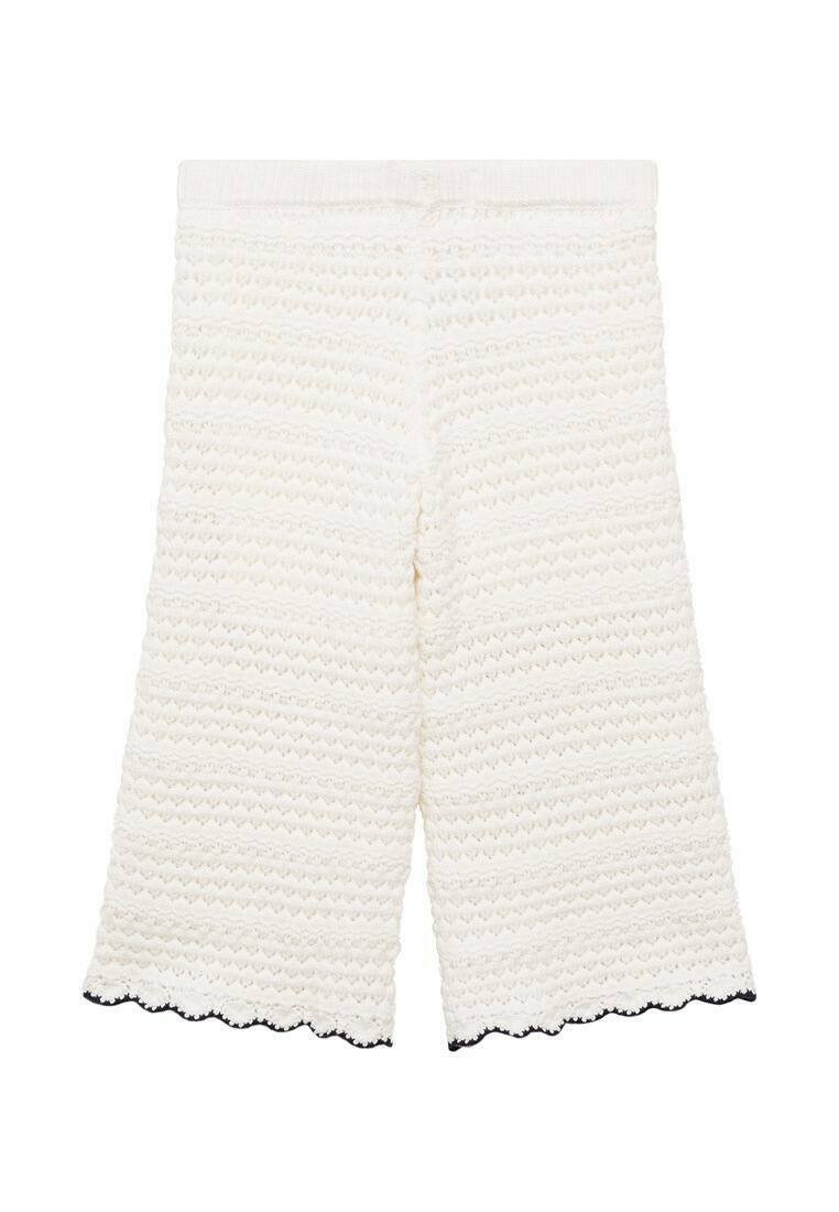 White textured cropped pants with a wavy pattern, featuring a scalloped hemline in black. Elastic waistband for comfort.