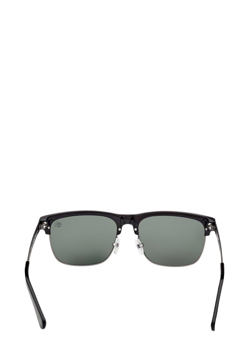 Zwarte halfrand zonnebril met rechthoekige groen getinte lenzen en verstelbare neuspads, van voren bekeken op een witte achtergrond.