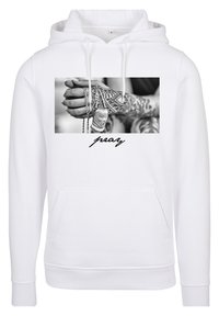 Sudadera con capucha blanca con un gráfico frontal de manos tatuadas sosteniendo cadenas y placas de identificación, acentuado por la palabra "rezar" en una fuente cursiva.