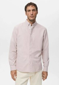 Camisa de manga larga de color rosa claro con botones y cuello, con un corte clásico, textura suave y cierre de botones al frente. Diseñada para uso casual.