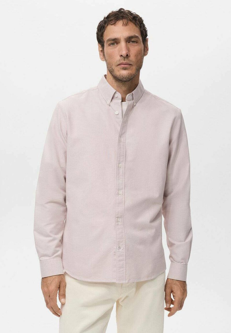 Camisa de manga larga de color rosa claro con botones y cuello, con un corte clásico, textura suave y cierre de botones al frente. Diseñada para uso casual.