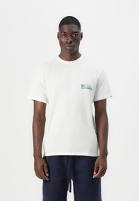 White cotton t-shirt with short sleeves, featuring a small blue and green logo on the left chest. Simple crew neckline and relaxed fit.