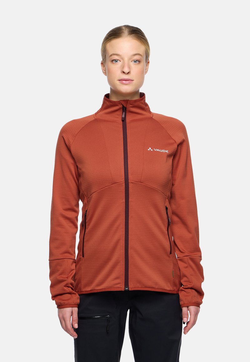 Giacca zip-up Vaude in arancione bruciato, con una finitura testurizzata, colletto alto e due tasche laterali con zip. Logo sul lato superiore sinistro del petto.