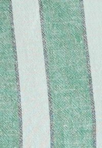 Svītrainā audumā ir maiņojošas piparmētru zaļas un gaiši beigu krāsas svītras. Mīksta tekstūra ar smalku spīdumu, apmalēs ir smalki apdari.