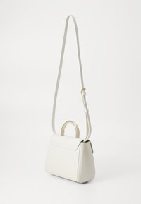 Borsa a mano in pelle bianca con hardware dorato, forma strutturata, manico superiore e una lunga tracolla regolabile. Texture liscia e design minimalista.