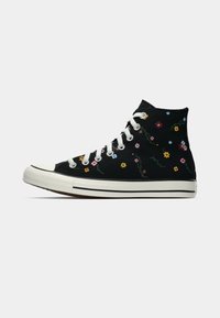 Zwarte hoge sneakers met kleurrijke bloemenborduurwerk, witte veters en rubberen neuskap. Heeft een witte middenzool met een zwarte streep.