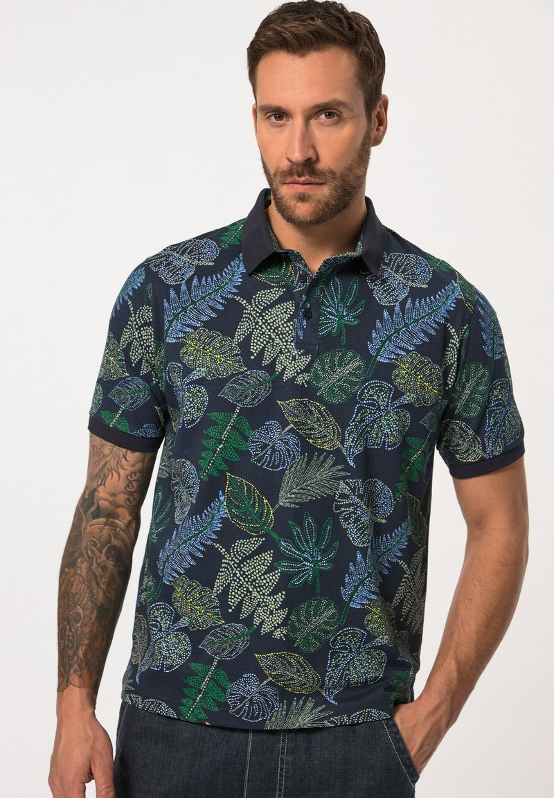 Polo a maniche corte in cotone blu navy, con un motivo a foglie multicolore con accenti verdi, blu e gialli, e colletto a punta.