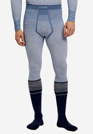 Man draagt blauwe thermoleggings met patroon en kniebescherming, en donkerblauwe kniekousen met grijze strepen.