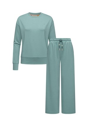 Világoskék pulóver és bőszárú nadrág szett, puha anyagból készült. Hosszú ujjak, kerek nyakkivágás és állítható zsinóros derék jellemzi.