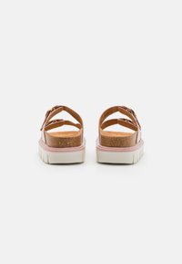 Sandales en cuir marron avec deux sangles ajustables, semelle en liège et une semelle de plateforme rose clair. Présente une surface texturée et un intérieur doux.