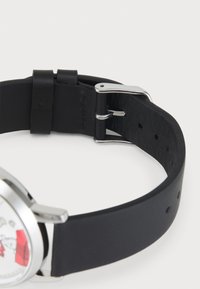Black leather watch strap with silver hardware, featuring a smooth texture and multiple adjustment holes for a secure fit.