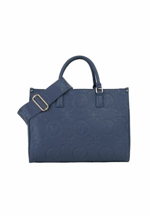 Sac à main en cuir bleu marine avec motifs floraux et circulaires en relief, deux poignées et une bandoulière en tissu réglable avec boucle en métal.