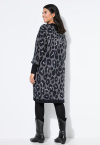 Grijze en zwarte luipaardprint cardigan met lange mouwen, geribbelde boorden en zoom. Draag het over zwarte leggings en combineer het met zwarte laarzen met studs.