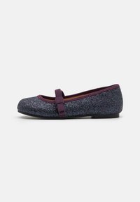 Glitzernde lila Ballerinas mit flacher Sohle, abgerundete Spitze und einem dekorativen Riemen über dem oberen Teil. Glatte Textur, funkelndes Finish.