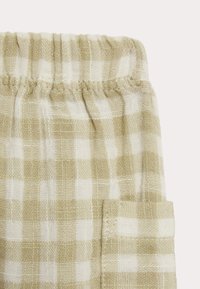 Pantaloni corti leggeri in misto cotone con un motivo a quadri khaki e bianchi, una vita elastica e una tasca laterale.