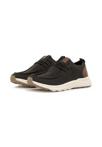 Zapatillas de malla negras con detalles en cuero marrón y suelas de goma blanca, que presentan un upper texturizado, diseño de cordones y puntera redonda.