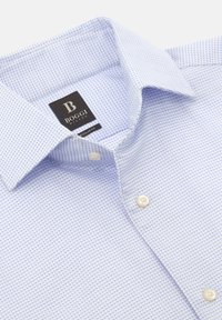 Světle modrá košile s malým čtvercovým vzorem, s límečkem na knoflíky a bílými knoflíky. Označení značky viditelné poblíž výstřihu.