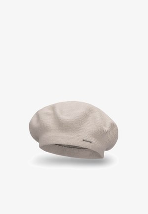 Beige strikket bøllehat med en blød tekstur, der har en flad krone og løs pasform. Inkluderer et lille metallisk logo som accent på siden.