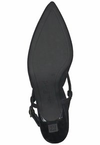 Scarpa nera con tacco alto, punta affusolata e cinturini alla caviglia. Texture in suede con parte inferiore liscia e marchio sulla suola.