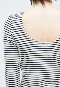 Bluzka z długim rękawem w paski w kolorach granatowym i białym, z niskim, okrągłym dekoltem na plecach, wykonana z miękkiej bawełny.
