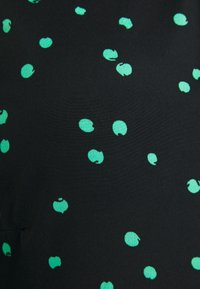 Schwarzer Stoff mit einer glatten Textur, der über die gesamte Oberfläche verstreute grüne Pünktchen in unterschiedlichen Größen und Formen aufweist.