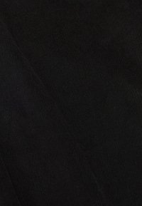 Černá kordurovná látka s viditelnými texturovanými vrstvami, vykazující hladký povrch a tmavou, jednotnou barvu. Žádné další vzory nebo detaily.