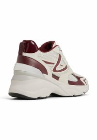 Basket de sport avec un dessus en maille beige et des accents synthétiques bordeaux. Présente une semelle intermédiaire blanche épaisse et une semelle extérieure en caoutchouc texturé.