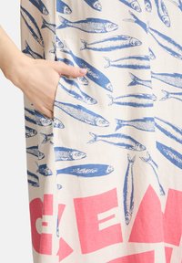 Baumwollkleid mit einem Allover-Druck von blauen Fischen auf beigem Hintergrund, mit einem auffälligen pinken Schriftzug und einer Seitentasche.