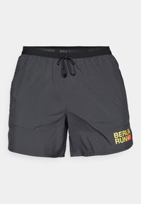 Czarne spodenki sportowe wykonane z lekkiego materiału, z elastycznym paskiem w talii i sznurkiem do ściągania oraz grafiką "BERLIN RUN" w kolorze żółtym.