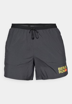 Schwarze Sportshorts aus leichtem Stoff, mit einem elastischen Bund und einer Kordel sowie einem gelben "BERLIN RUN" Grafik.