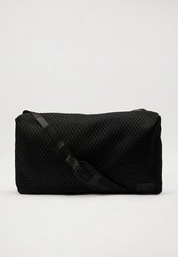 Black mesh shoulder bag with a textured surface, adjustable strap, and a rectangular shape. Features a logo accent on one side.