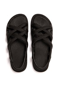 Sandalias negras hechas de material sintético texturizado, con correas entrelazadas y un diseño de punta abierta. Suela plana con una plantilla estampada.