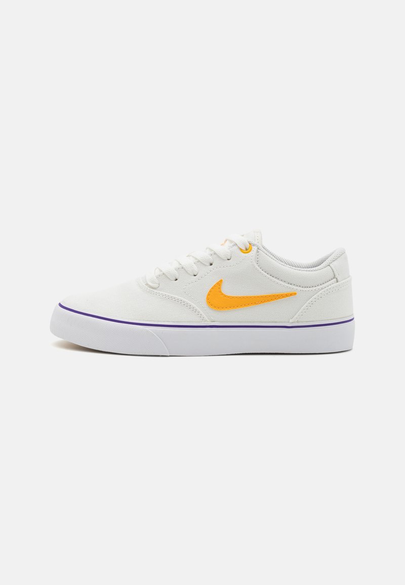 Sapatilhas de lona brancas com um logotipo da Nike laranja brilhante e um destaque roxo na sola. Apresenta atacadores redondos e um design de perfil baixo.