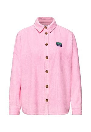 Camicia rosa in velluto a coste con maniche lunghe, bottoni in legno sul davanti e una piccola toppa "Studio Club" sul petto sinistro.