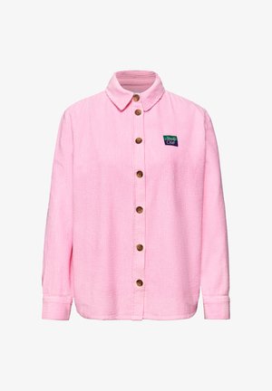 Roze lange mouwen corduroy overhemd met houten knopen aan de voorkant en een kleine "Studio Club" patch op de linkerborst.