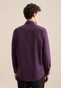 Langsleeve shirt in dieppaarse stof, met een standaard kraag, knoopmanchetten en een gladde textuur met minimale details.