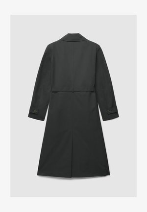 Long manteau gris foncé avec une texture lisse. Comprend un col cranté, des manches longues avec poignets boutonnés, et une ceinture à la taille pour ajustement.